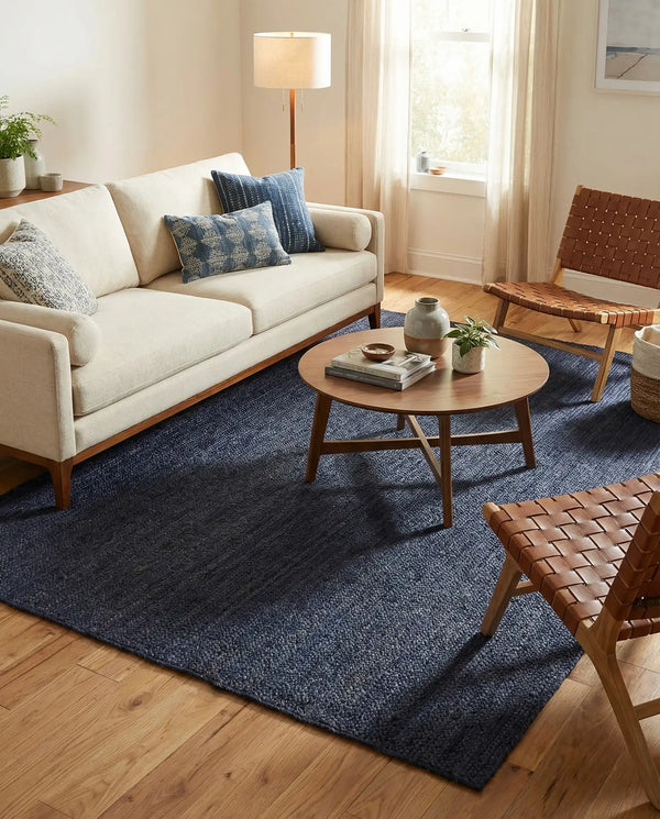 Navy blue handwoven textured area rug styled in a cozy modern living room with cream sofa and wooden furniture