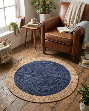A modern circular patterned round rug placed on a wooden floor in a styled living room setu